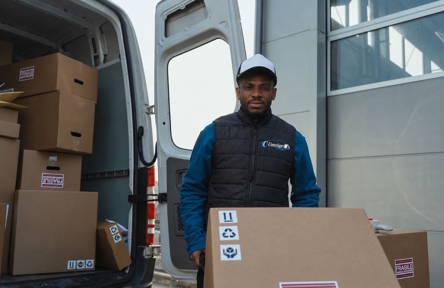 Umzugshelfer von C-Umzüge mit Sackkarre und Kartons vor einem Transporter